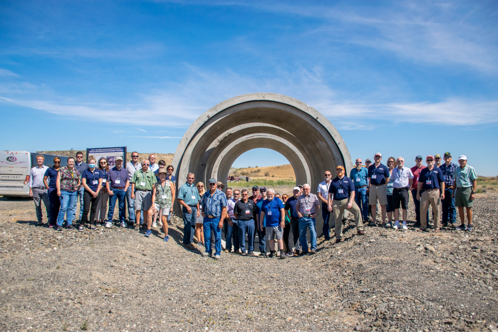 Landscape shot of East Columbia Basin Irrigation District Employees standing in front of a concrete pipeline that will be used for irrigation water